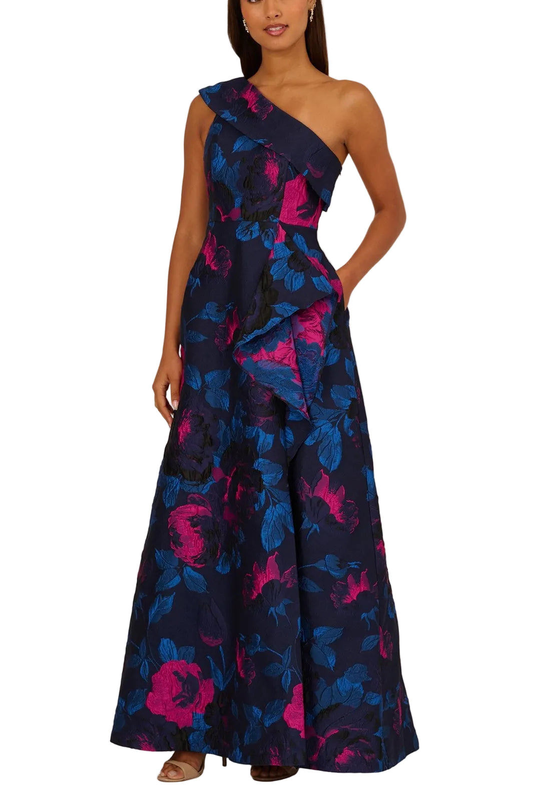 Woman wearing a one-shoulder floral dress with pink and blue flowers on a beige background